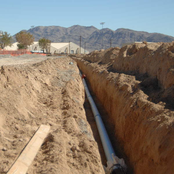 Benching in a long trench with a pipe.
