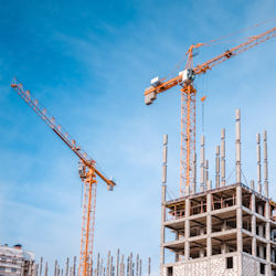 Two tower cranes surrounding a work site