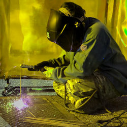 Welder working in enclosed space with exhaust ventilation