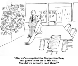 Humorous cartoon of two workers in suits viewing suggestion box papers on wall 
