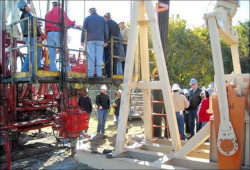 Crowd of workers receiving an overview of a drilling rig