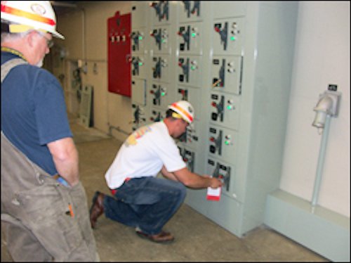 Worker being supervised while placing a lockout / tag out tag.