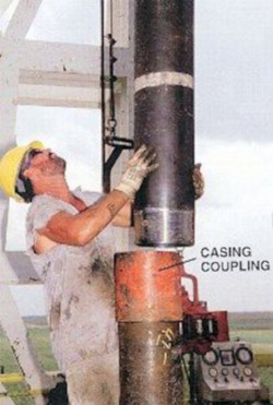Worker guiding the casing coupling into place