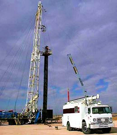 Tubing rig near a white utility truck
