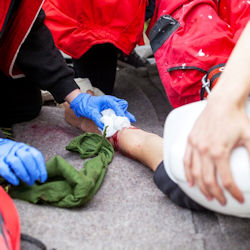First aid being administered to worker with a cut on the arm