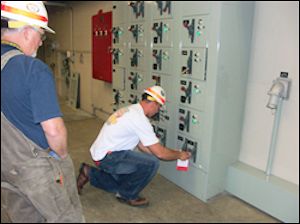 Two workers at electrical panel